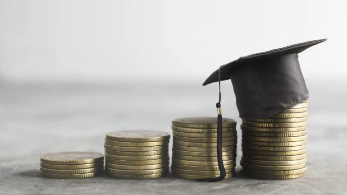 Four stacks of coins, progressively getting higher, with a university style hat sat upon the last stack.