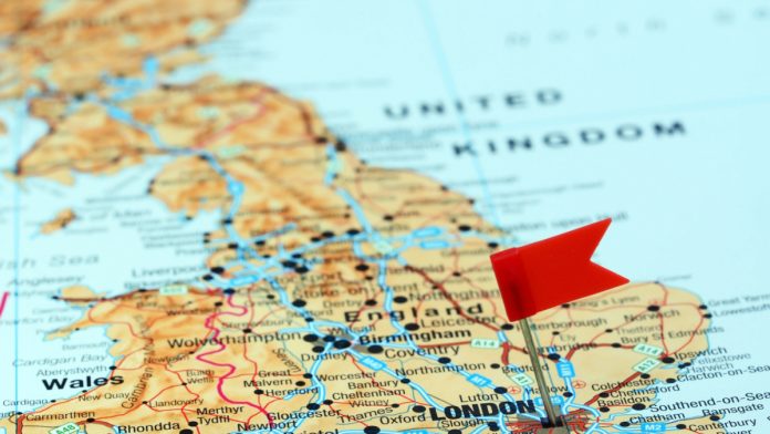 Red flag stuck in a map of the UK signifying London.