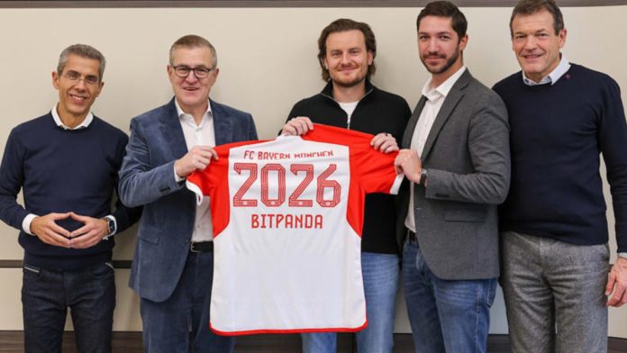 Bitpanda and Bayern Munich employees holding up football shirt.