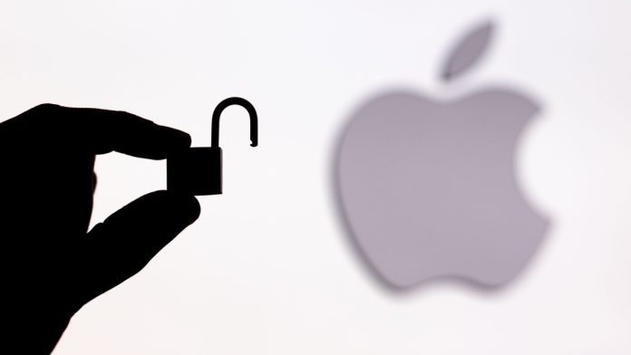 A person holding an unlocked padlock besides an Apple logo.