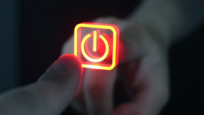 Finger touches the power button icon.