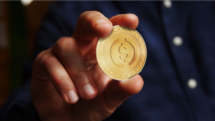 USDC cryptocurrency symbol golden USD coin in hand abstract concept.