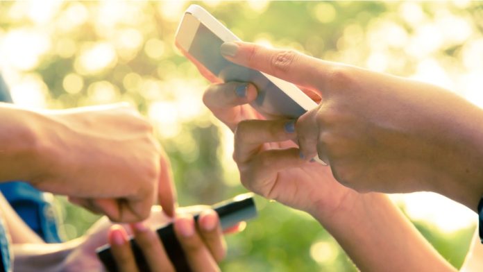 Two people with phones, symbolising Visa's Tap to Phone.