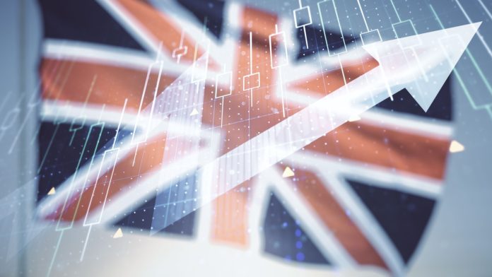 Abstract creative financial diagram and upward arrow hologram on flag of Great Britain and blue sky background, growth and development concept.