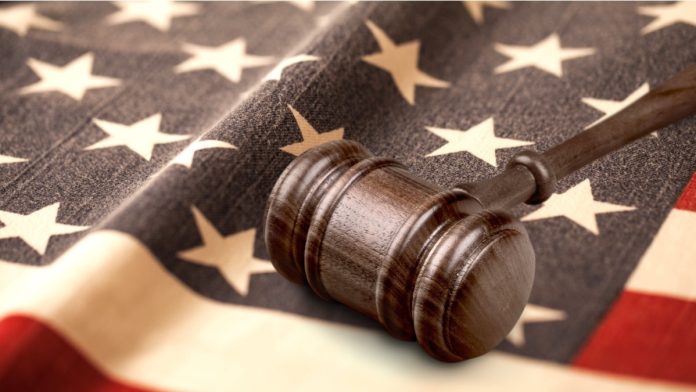 Judge's wooden gavel and USA flag.