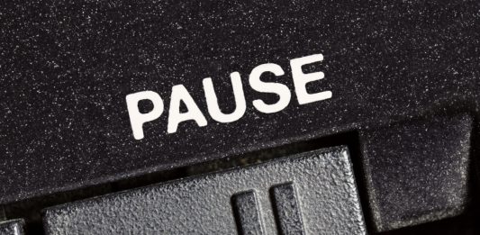 Macro close up photograph of vintage tape machine play and record pause button.