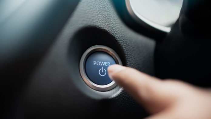 Finger ready to press car engine start stop button - car interior. Driver push the power on off button inside a car.