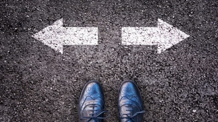Feet and two arrows painted on an asphalt road.