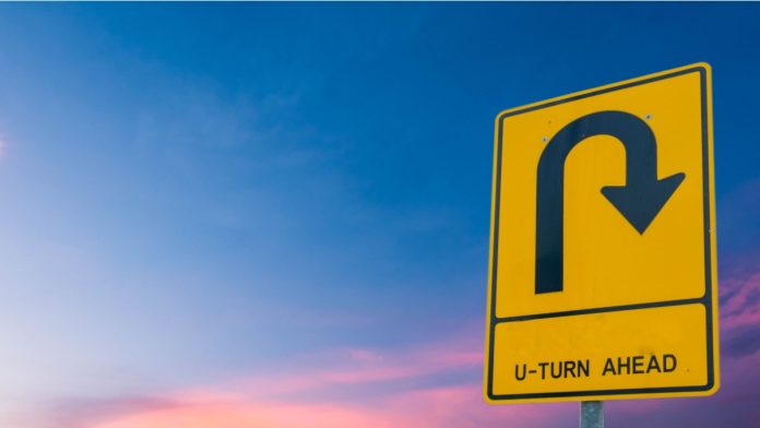 U-turn ahead On the sky background.
