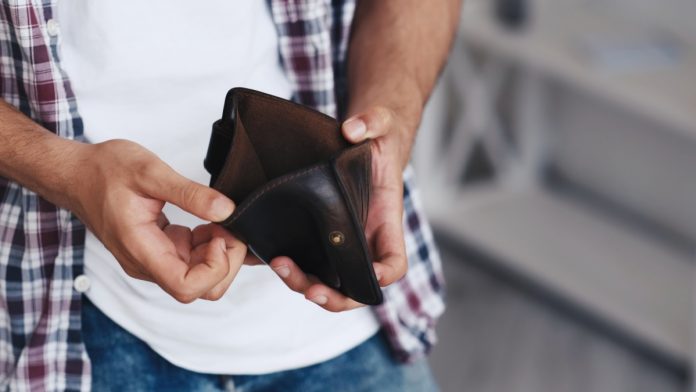 No money. Poverty problem. Financial crisis. Economy bankruptcy. Unrecognizable broke penniless poor man hands revealing empty wallet.