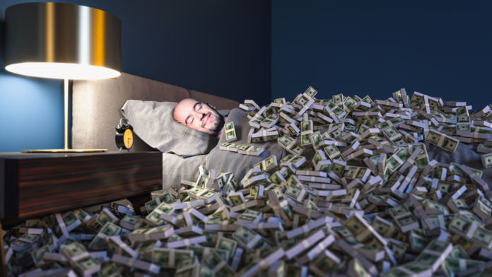 Man in bed covered with stacks of cash, representing embedded finance.