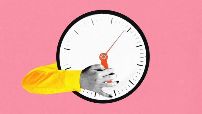 And image of a clock with hand holding one of the clock hands representing real-time