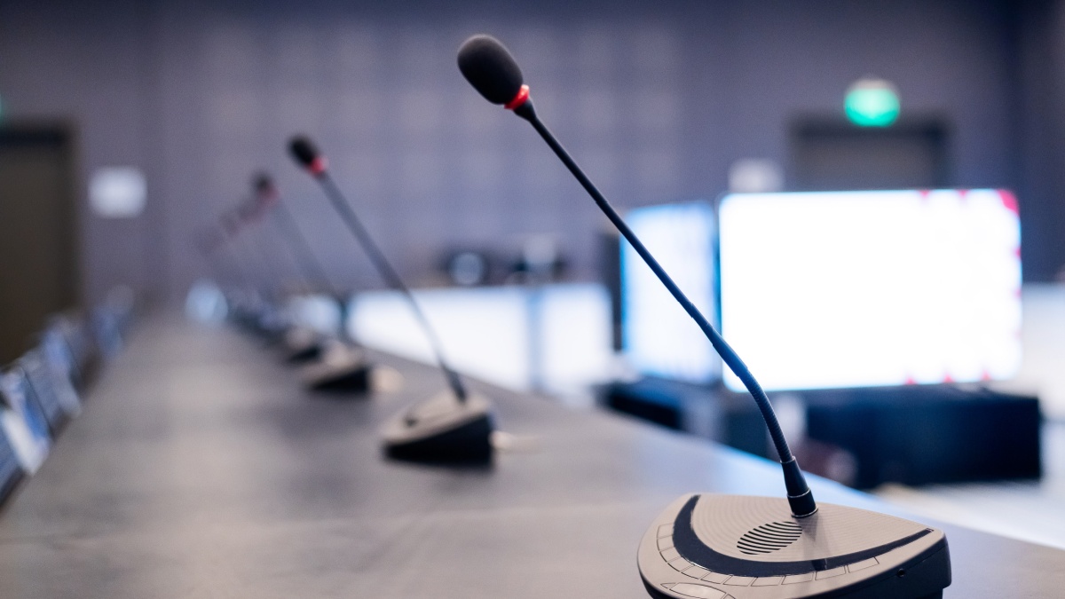 Close-up of microphones in an empty meeting room at a press conference.