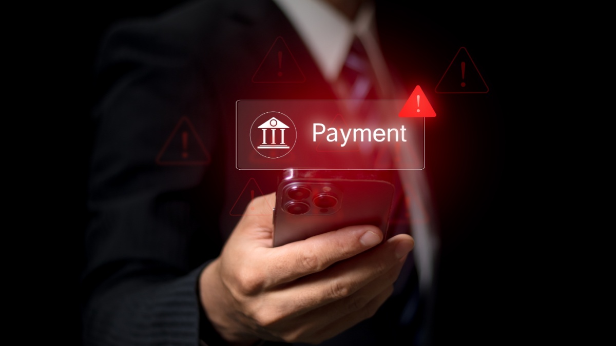 Online payment fraud warning during mobile transaction as man uses credit card and smartphone for digital banking, facing potential fraud, phishing, and cybersecurity threats in financial transactions.