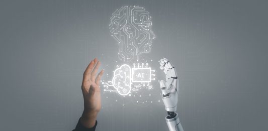 Human hand and robot hand with AI concept in between.