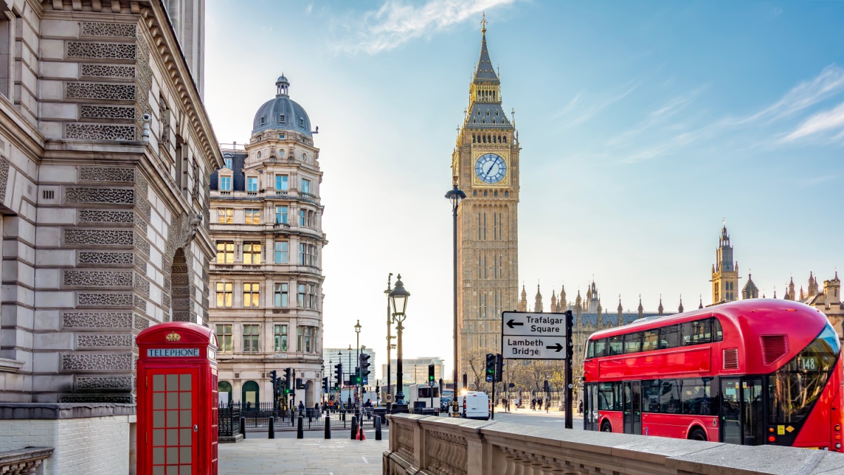 Red telephone box and double-decker bus on Parliament square and Big Ben tower, London, UK.