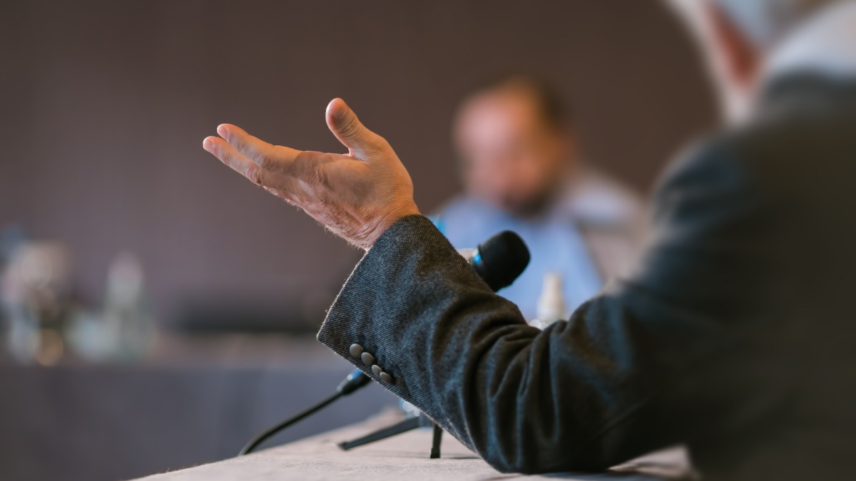 People debating at seminar presentation.