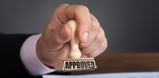 Close-up Of A Person's Hand Stamping On Approved Document.