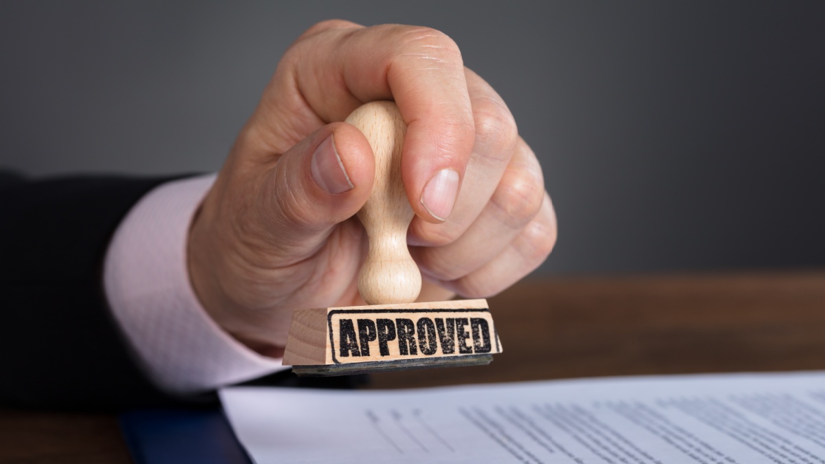 Close-up Of A Person's Hand Stamping On Approved Document.