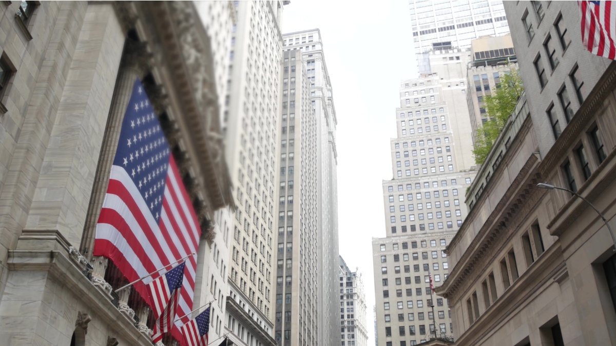 New York City, United States. Lower Manhattan Downtown Financial District urban architecture. Huge big American flag. Wall street Stock Exchange building, USA Stock Market trading.
