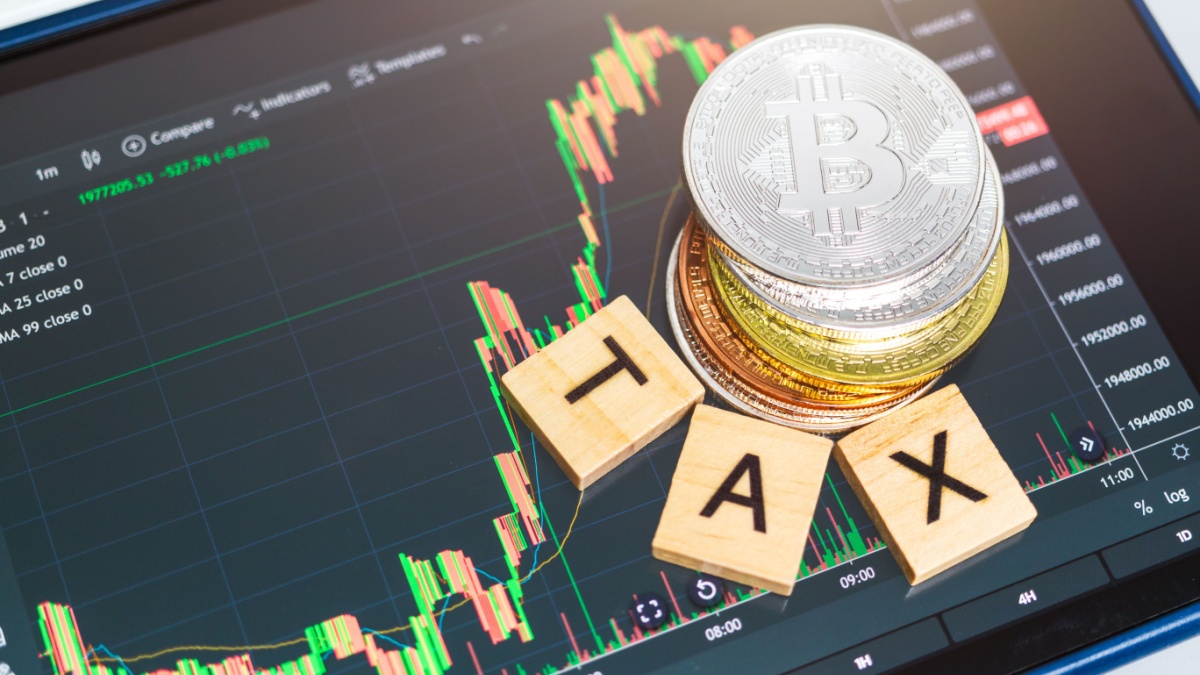Cryptocurrencies with TAX word and stock chart candlestick on tablets background, Digital money concept