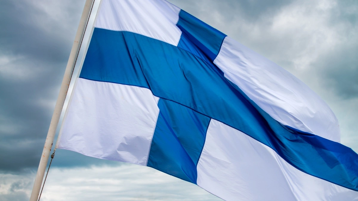 Finland national flag waving in the wind on a cloudy sky.