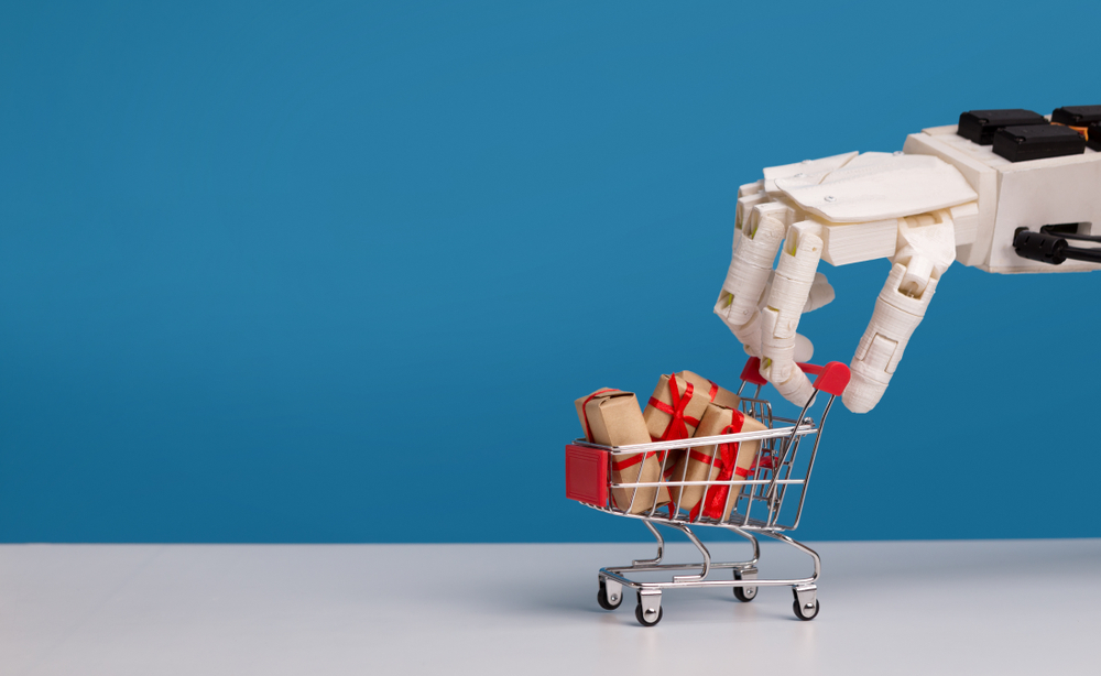 Future technology and consumerism. Robot hand holding shopping cart with gift boxes, blue background, free space