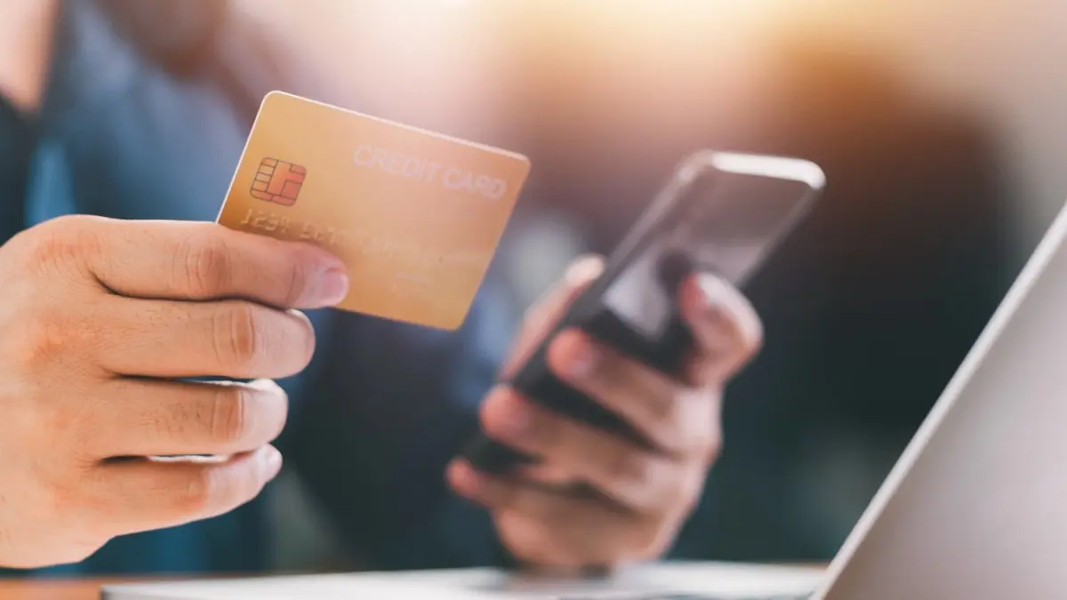 Close up Male hands holding credit card and smartphone, man paying online, credit card shopping.