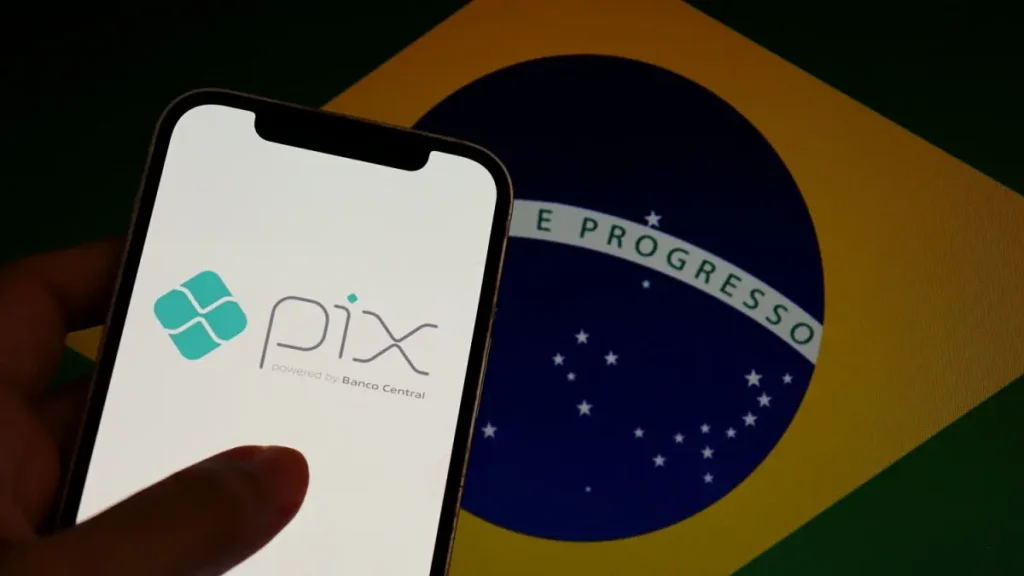 Pix logo on smartphone screen with brazilian flag in the background