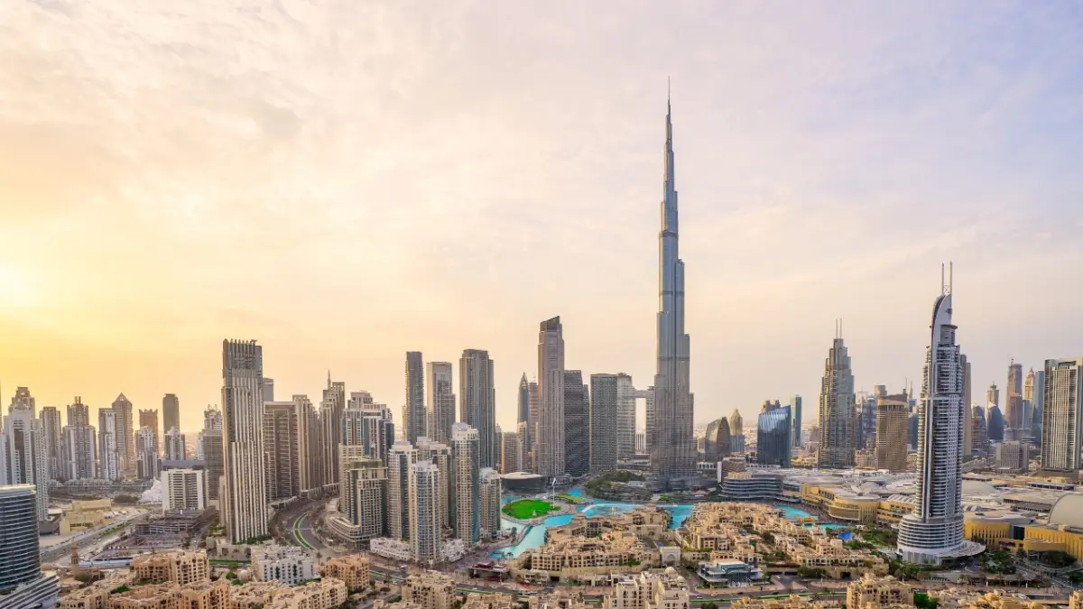 Sunrise skyline drama over Dubai’s downtown as the Burj Khalifa pierces the warm skies — aerial view of modern skyscrapers, urban architecture and golden hour cityscape in the UAE.