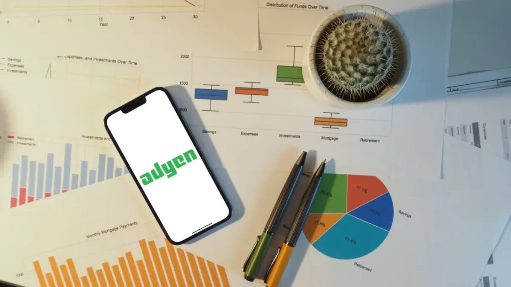 Adyen displayed on a phone, which is sat upon a piece of paper.