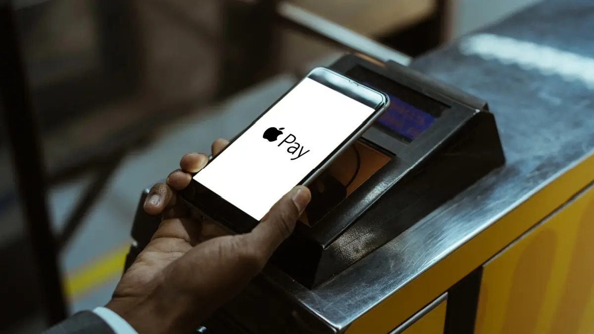 Close-up view of man using Apple Pay paying for public transport.