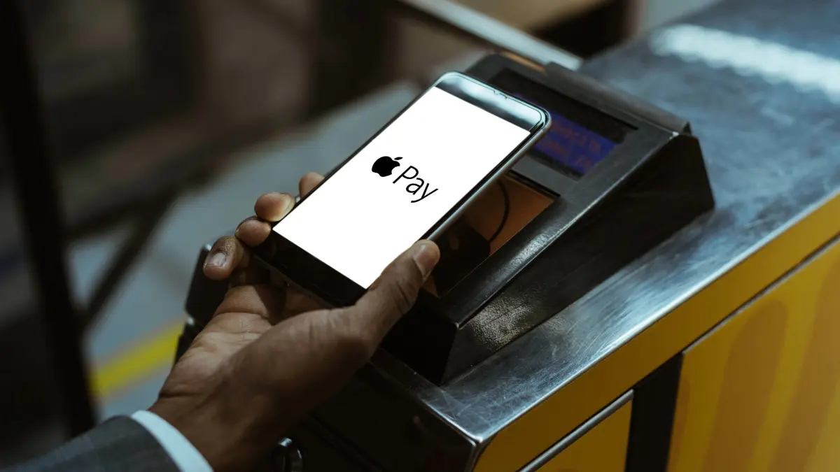 Close-up view of man using Apple Pay paying for public transport