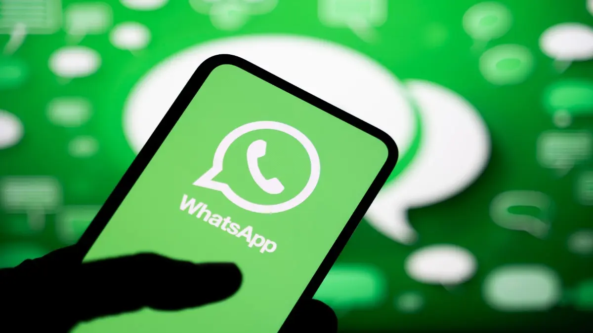 Paris, France, September 24, 2025: a man holds a smartphone displaying the logo of the WhatsApp instant messaging app with a green background featuring conversation bubbles.