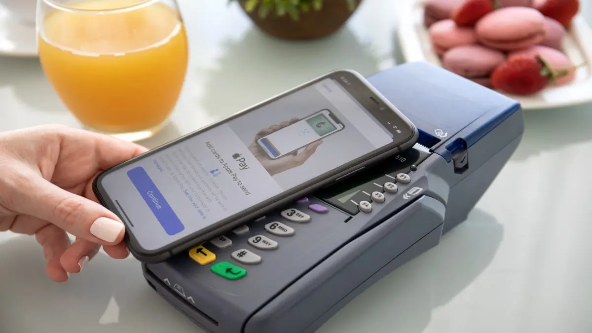 Alanya, Turkey - October 1 2019 : Waman hand holding iPhone 11 with Apple Pay on the screen and pay pass online terminal. iPhone was created and developed by the Apple inc.